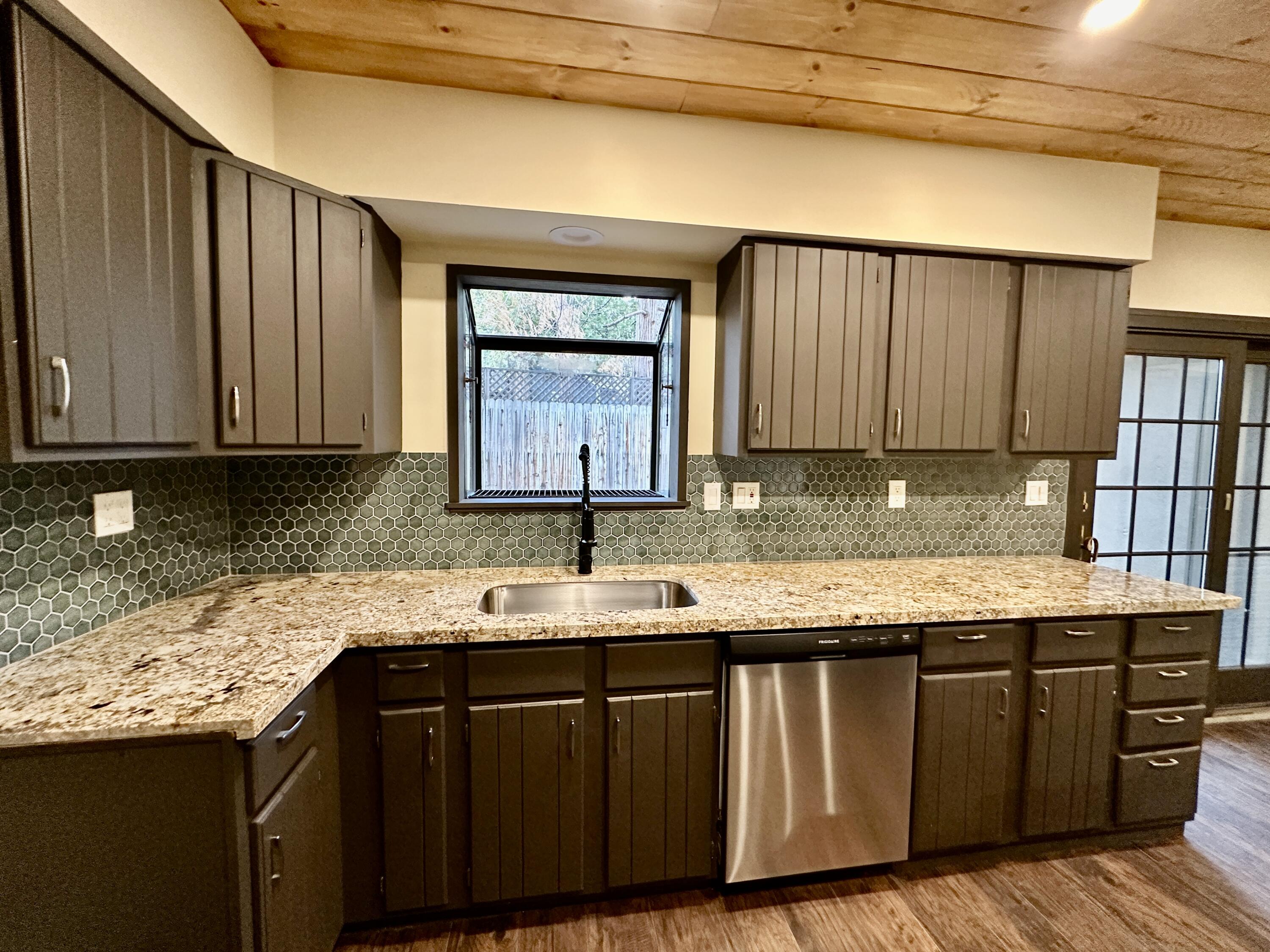 25340 Marion Ridge Drive Idyllwild, CA 92549 - Photo 10 of 31 a kitchen with granite countertop wooden cabinets a sink and dishwasher