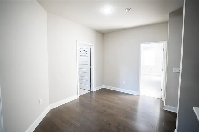 an empty room with wooden floor and closet