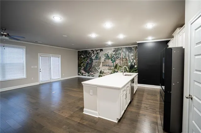 an open kitchen with a sink and refrigerator