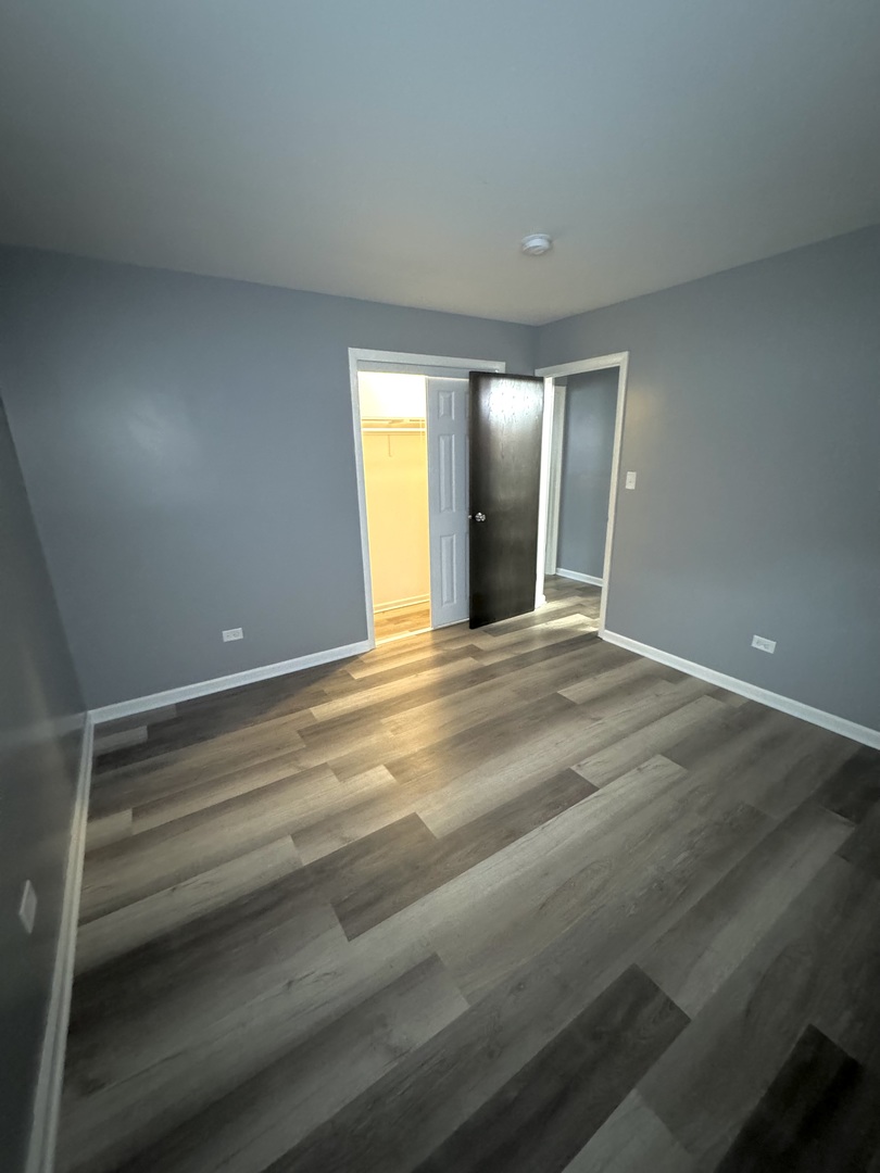 3642 147th Place Midlothian, IL 60445 - Photo 11 of 16 a view of an empty room with wooden floor and windows