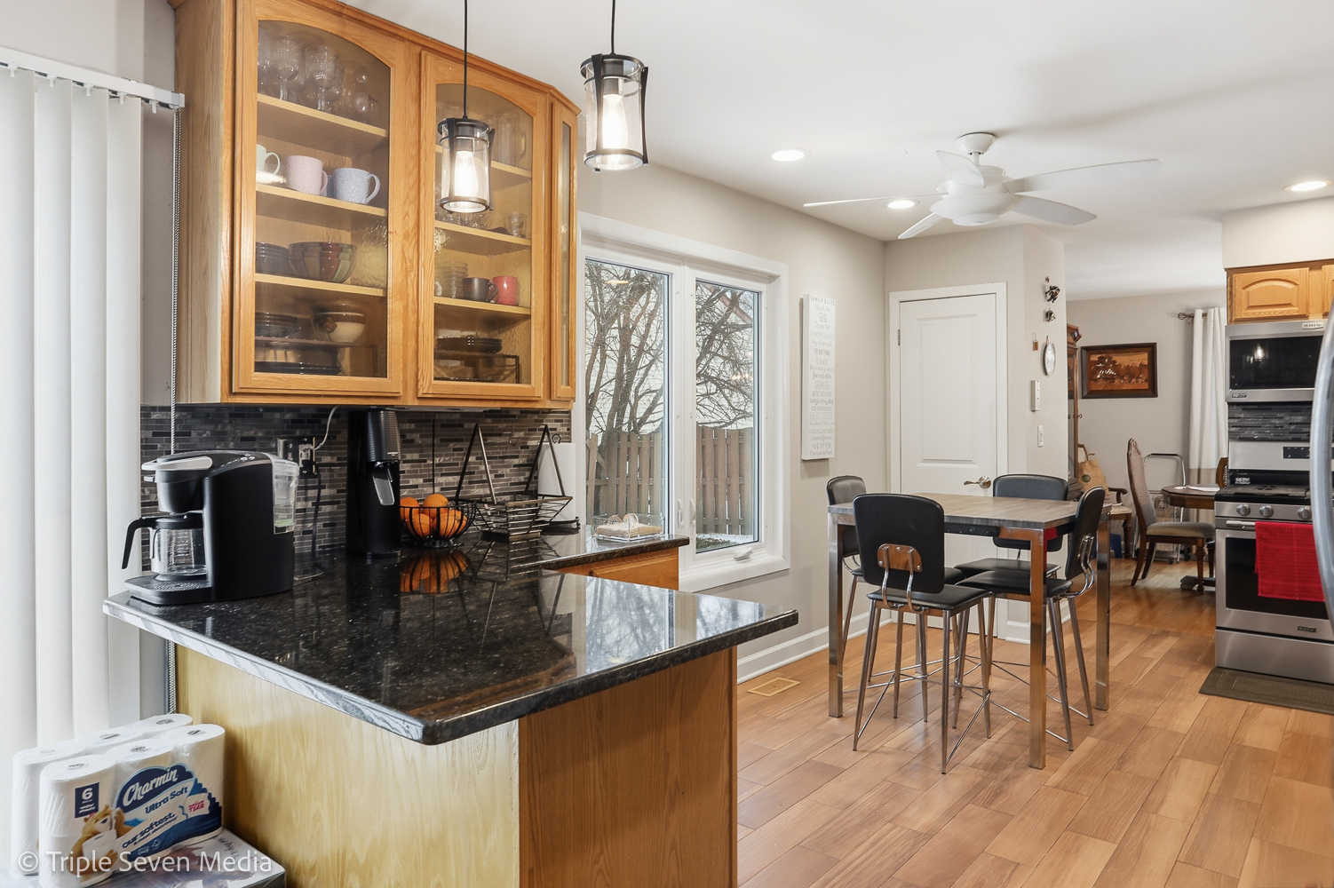 454 Stone Place Wheeling, IL 60090 - Photo 6 of 11 a kitchen with stainless steel appliances granite countertop a stove top oven a dining table and chairs with wooden floor
