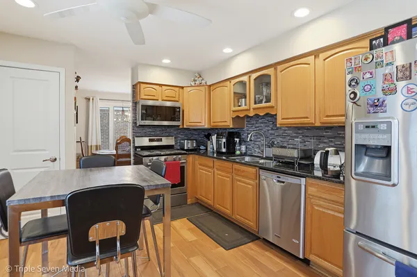 a kitchen with stainless steel appliances granite countertop a stove a sink a microwave a refrigerator and cabinets