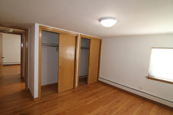 an empty room with wooden floor and closet