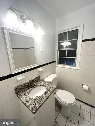a bathroom with a granite countertop sink a mirror and a toilet