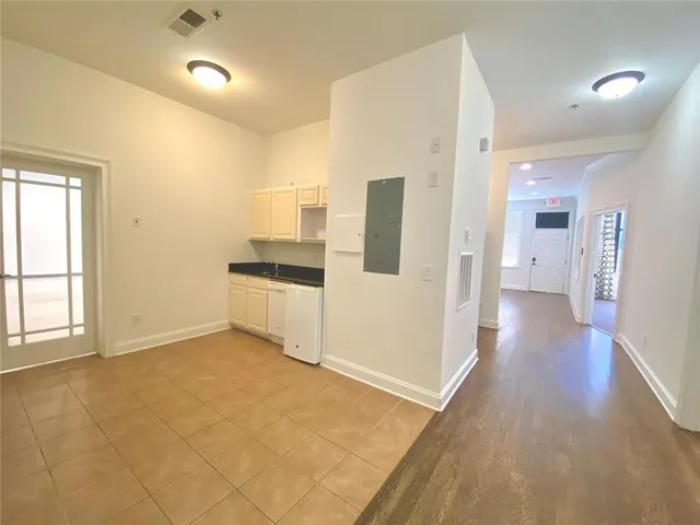 a view of a hallway with wooden floor and cabinet
