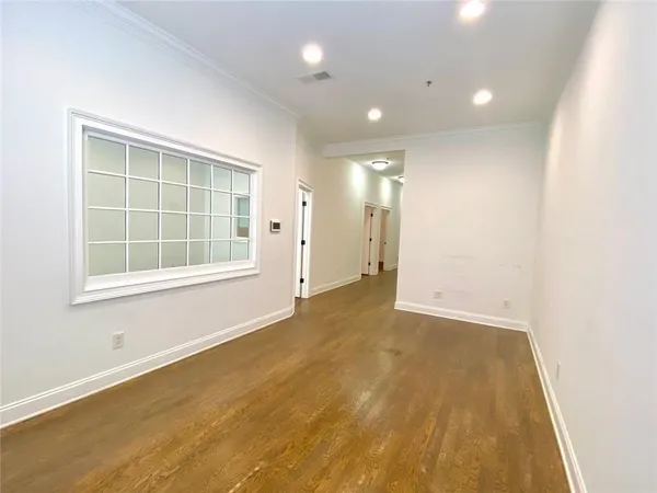 an empty room with wooden floor and windows
