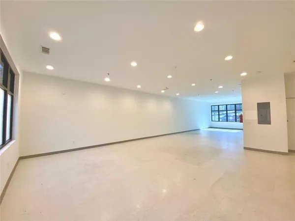 an empty room with windows and fireplace