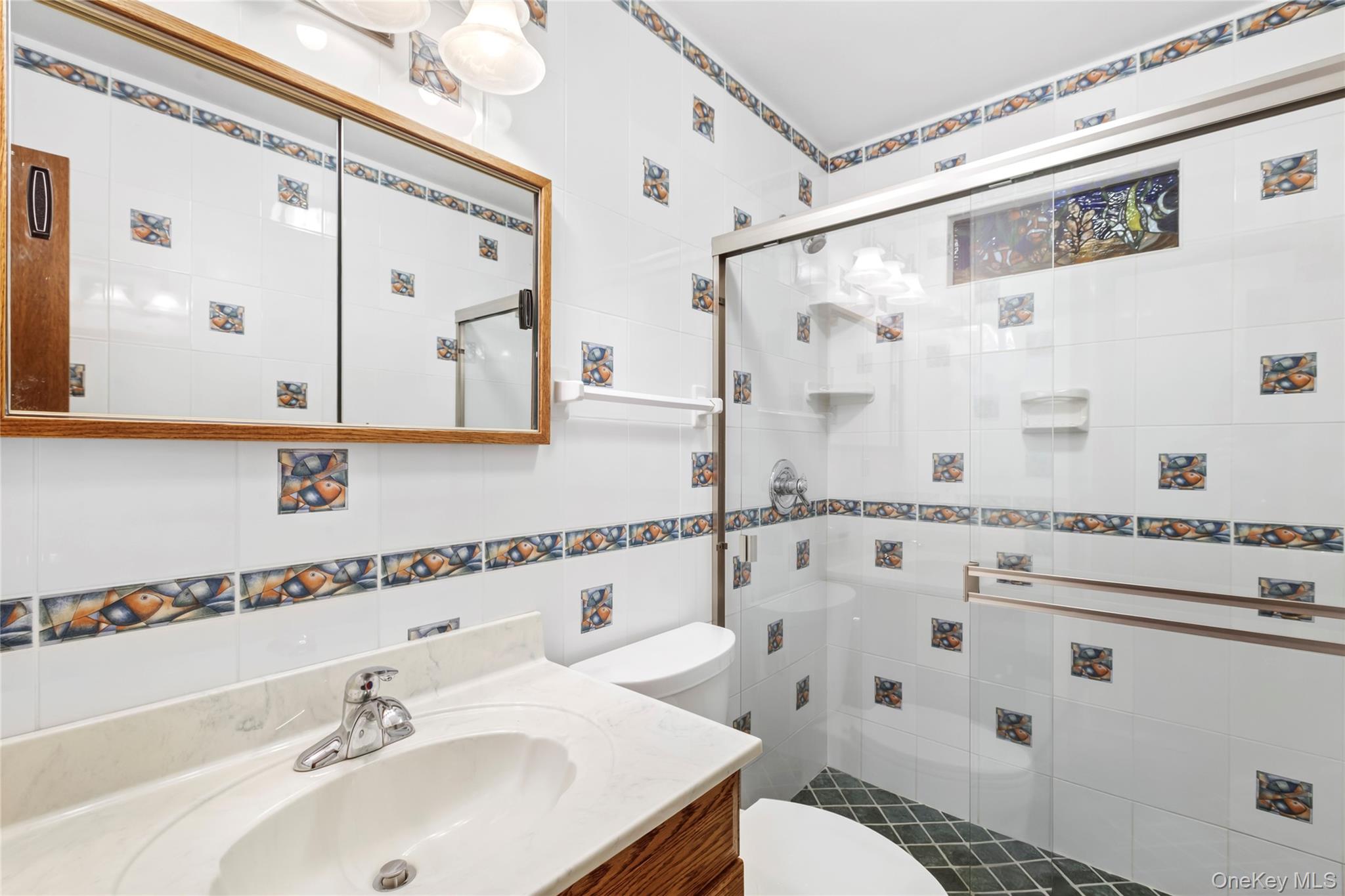 250 Paradise Point Road Southold, NY 11971 - Photo 13 of 24 a bathroom with a sink mirror vanity and toilet