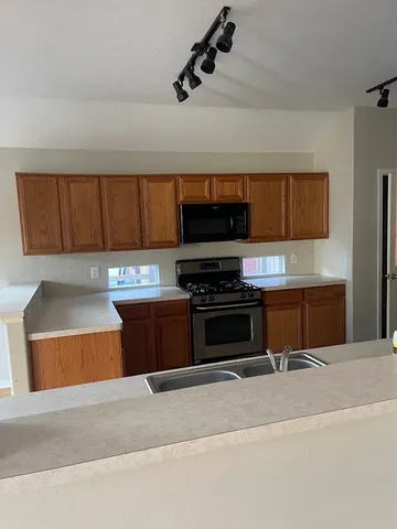 a kitchen with stainless steel appliances kitchen island granite countertop a stove and a sink with granite countertops