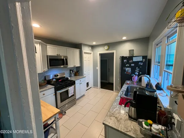 a kitchen with stainless steel appliances kitchen island granite countertop a stove and a sink
