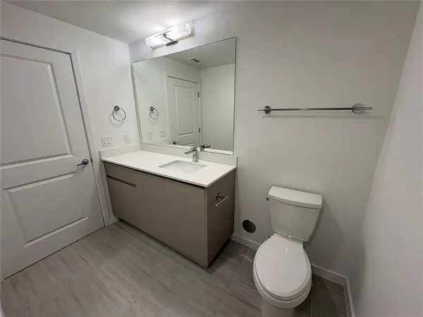 a bathroom with a toilet sink and a mirror