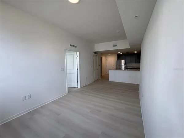 a view of a hallway with wooden floor and a bathroom