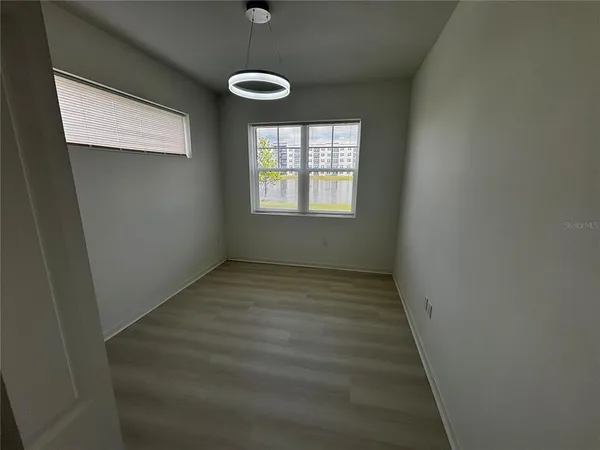 a view of a hallway with wooden floor and a bathroom