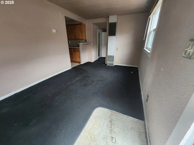a view of a hallway with wooden floor and a kitchen
