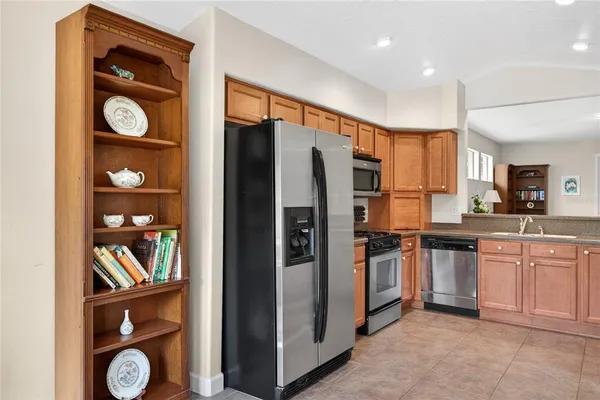 a kitchen with stainless steel appliances granite countertop a refrigerator and a stove top oven