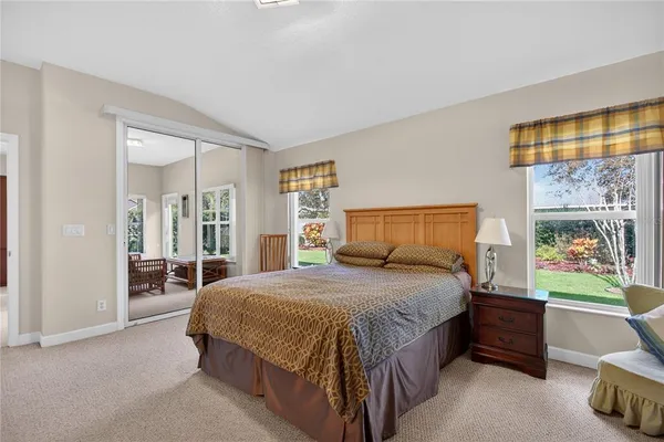 a spacious bedroom with a bed and a large window