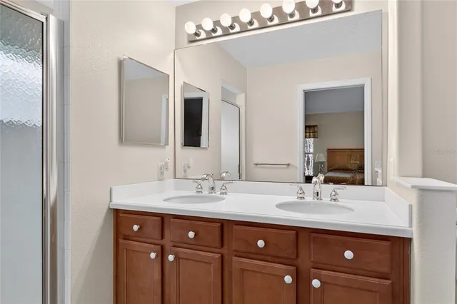 a bathroom with double vanity and a mirror