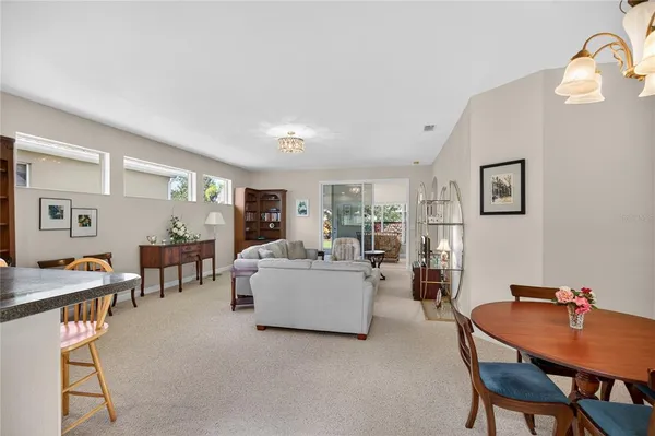 a living room with furniture and a dining table with rug