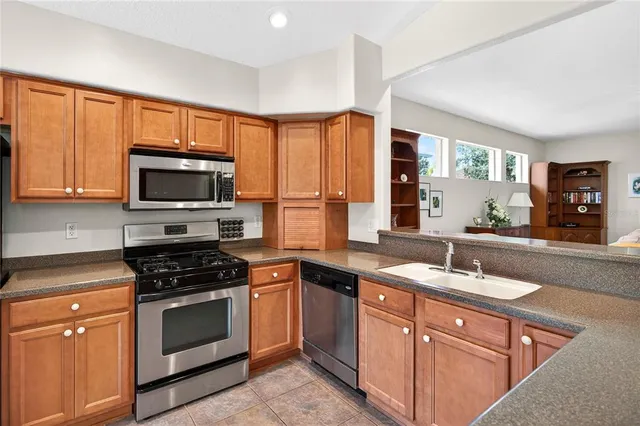 a kitchen with stainless steel appliances granite countertop a refrigerator and a sink