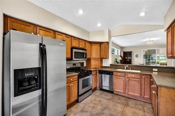 a kitchen with stainless steel appliances granite countertop a refrigerator and a sink