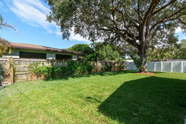 a view of backyard with table and chairs and potted plants