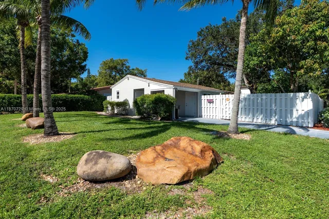 a view of a house with backyard and sitting area