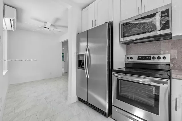 a metallic refrigerator stove sitting inside of a kitchen