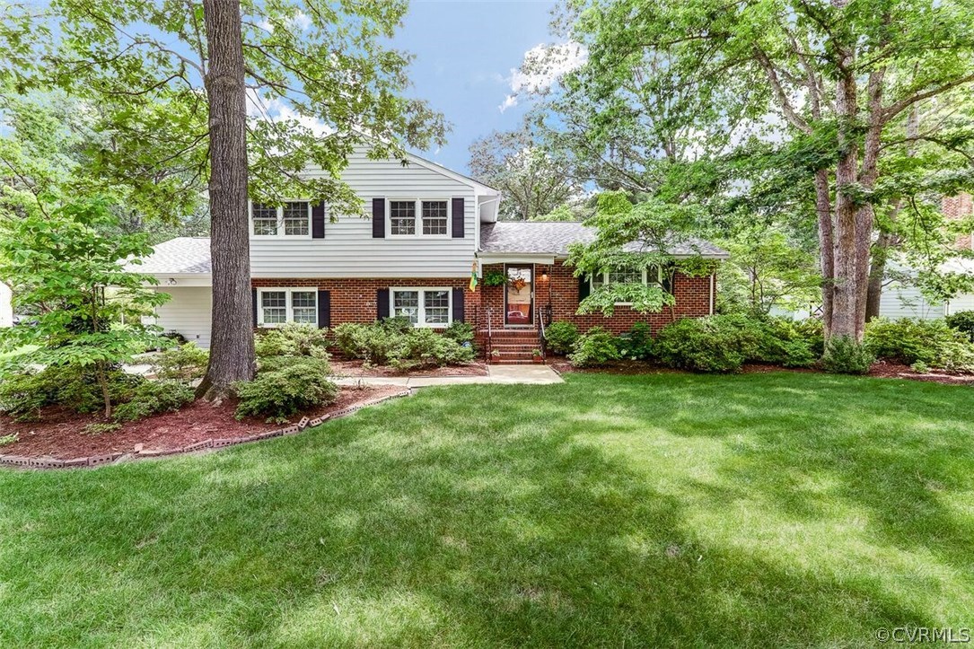11431 Rochelle Road Chester, VA 23831 - Photo 1 of 23 a front view of a house with a garden and trees