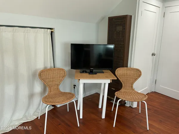 a view of a workspace with furniture and wooden floor