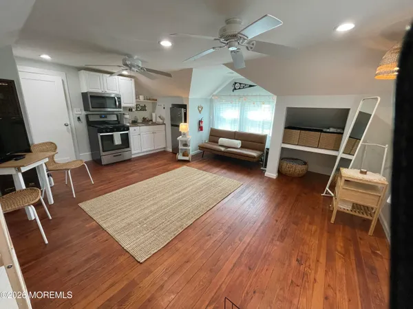a living room with stainless steel appliances kitchen island granite countertop furniture wooden floor and a view of kitchen