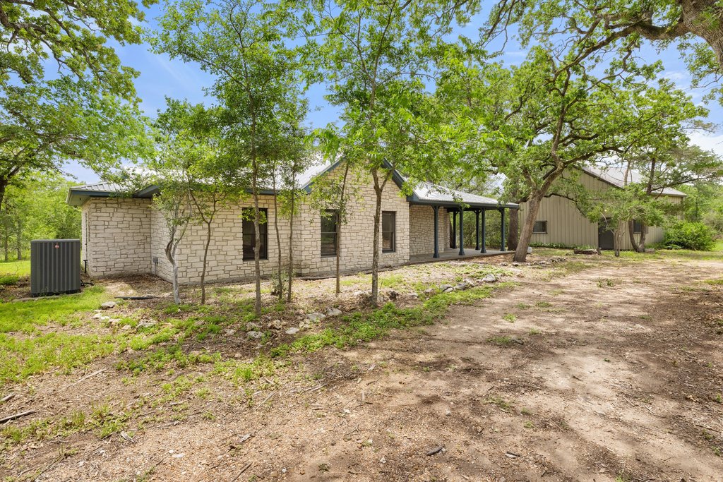 244 Woodway Elgin, TX 78621 - Photo 3 of 40 a backyard of a house with large trees and brick walls