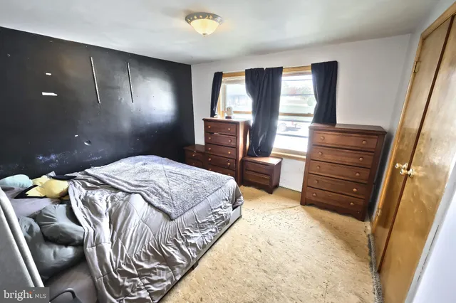a bedroom with a bed and dresser with mirror