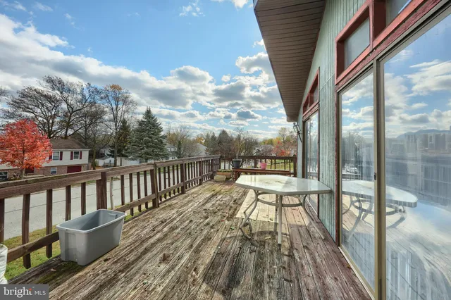 a view of roof deck with wooden floor and fence