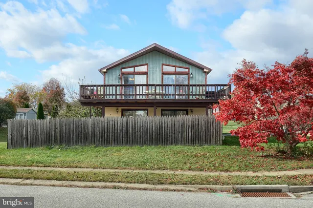a view of a house with a yard and wooden fence