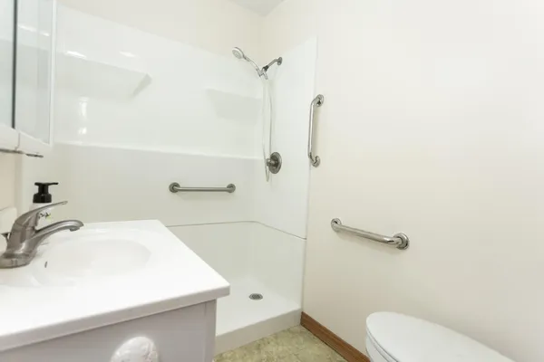 a bathroom with a sink a toilet and shower