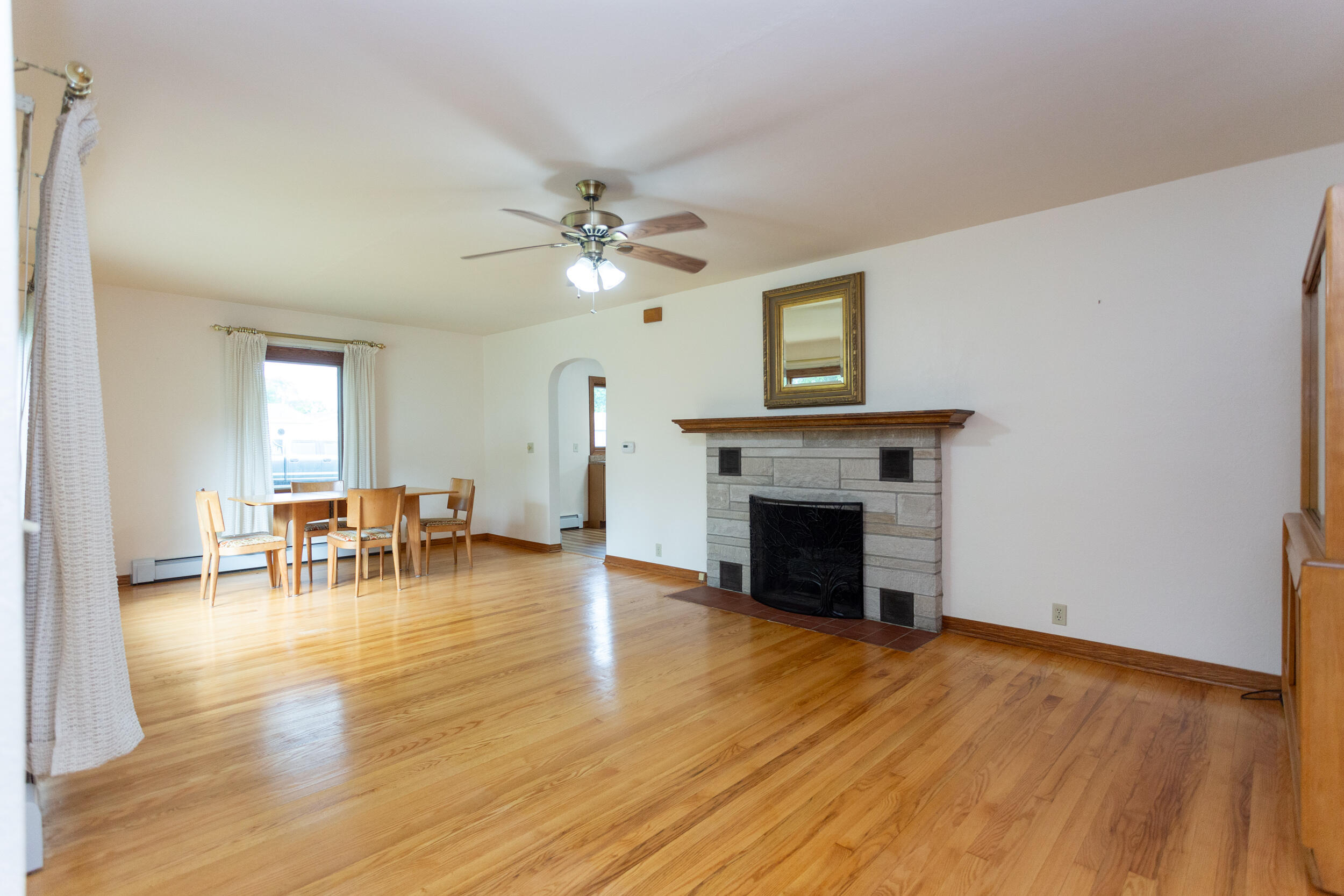 601 East Main Street La Crosse, IN 46348 - Photo 5 of 29 an empty room with fireplace wooden floor and a window