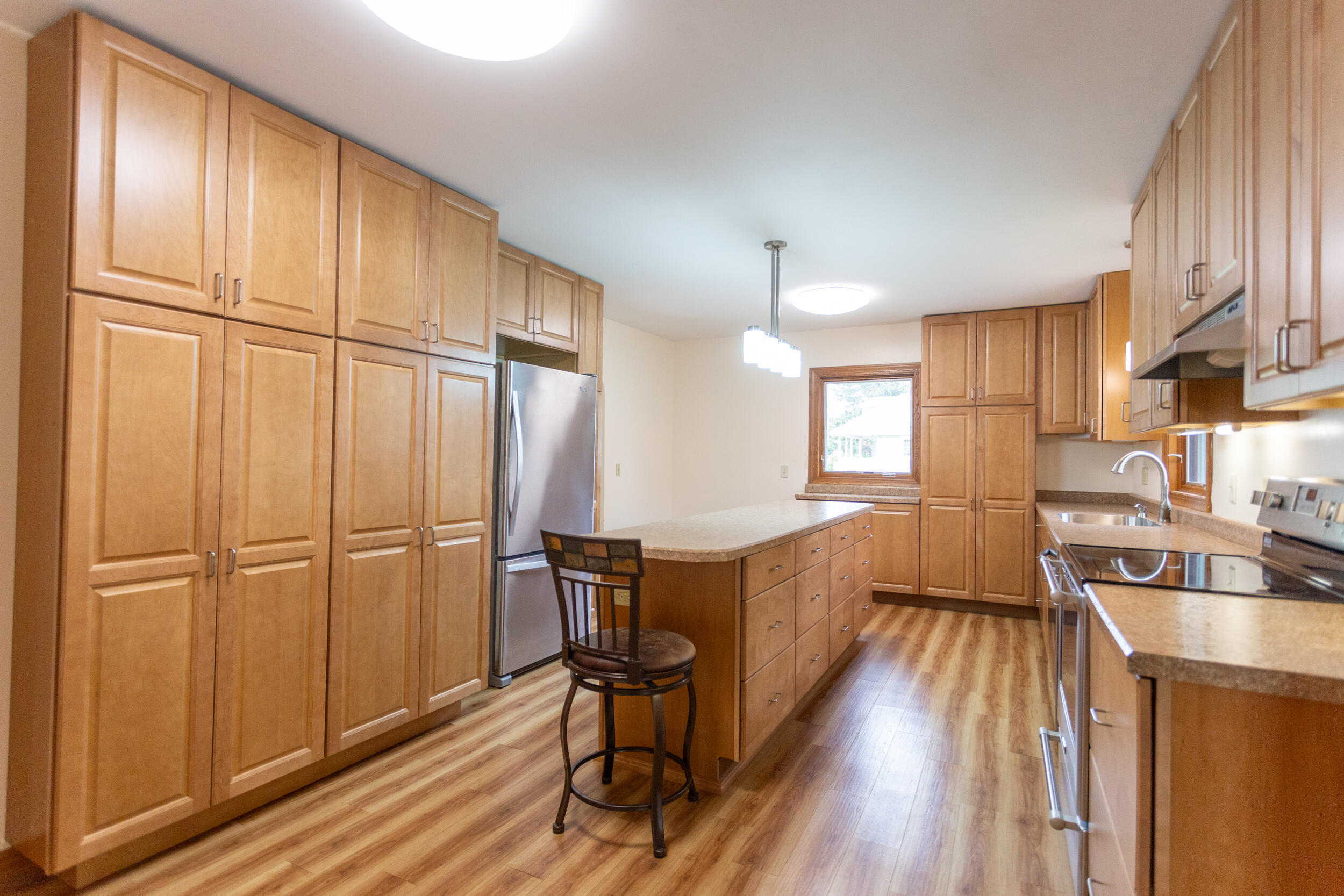 601 East Main Street La Crosse, IN 46348 - Photo 9 of 29 a kitchen with stainless steel appliances granite countertop a refrigerator a sink dishwasher a stove and white countertops with wooden floor