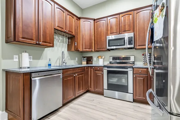 a kitchen with stainless steel appliances granite countertop a refrigerator stove and a sink