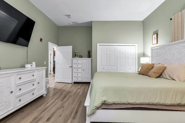 a bedroom with a bed and wooden floor