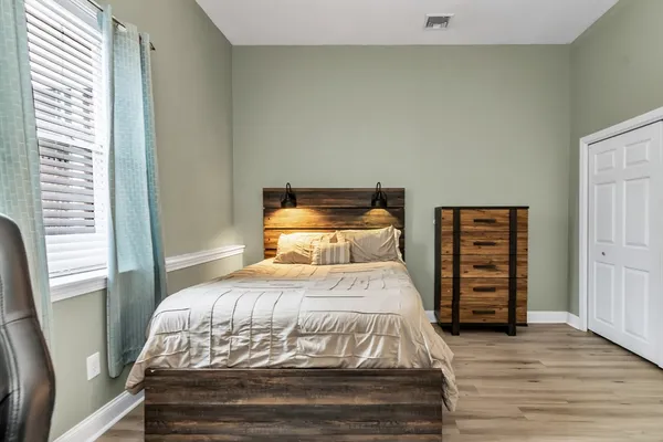 a bedroom with a bed and wooden floor