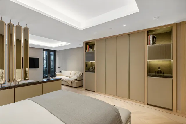 a bedroom with a bed and large windows