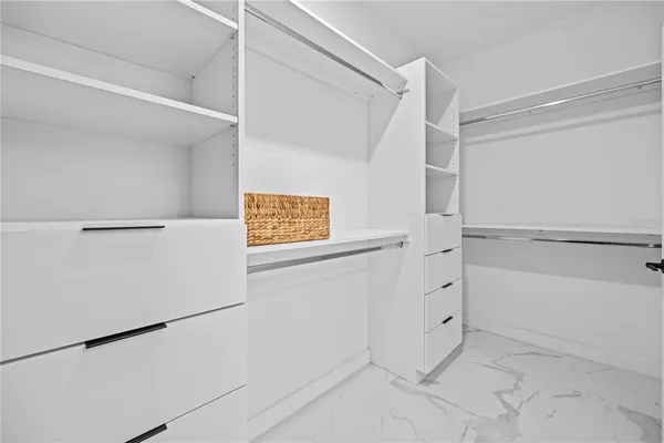 a view of walk in closet with empty racks