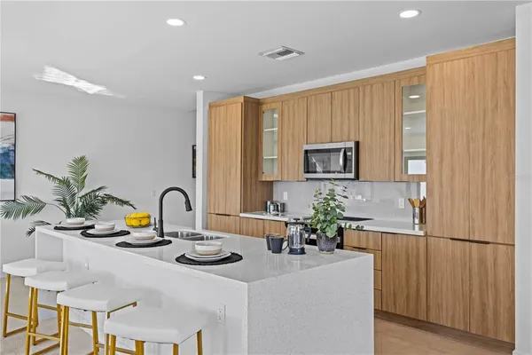 a kitchen with a sink refrigerator and microwave