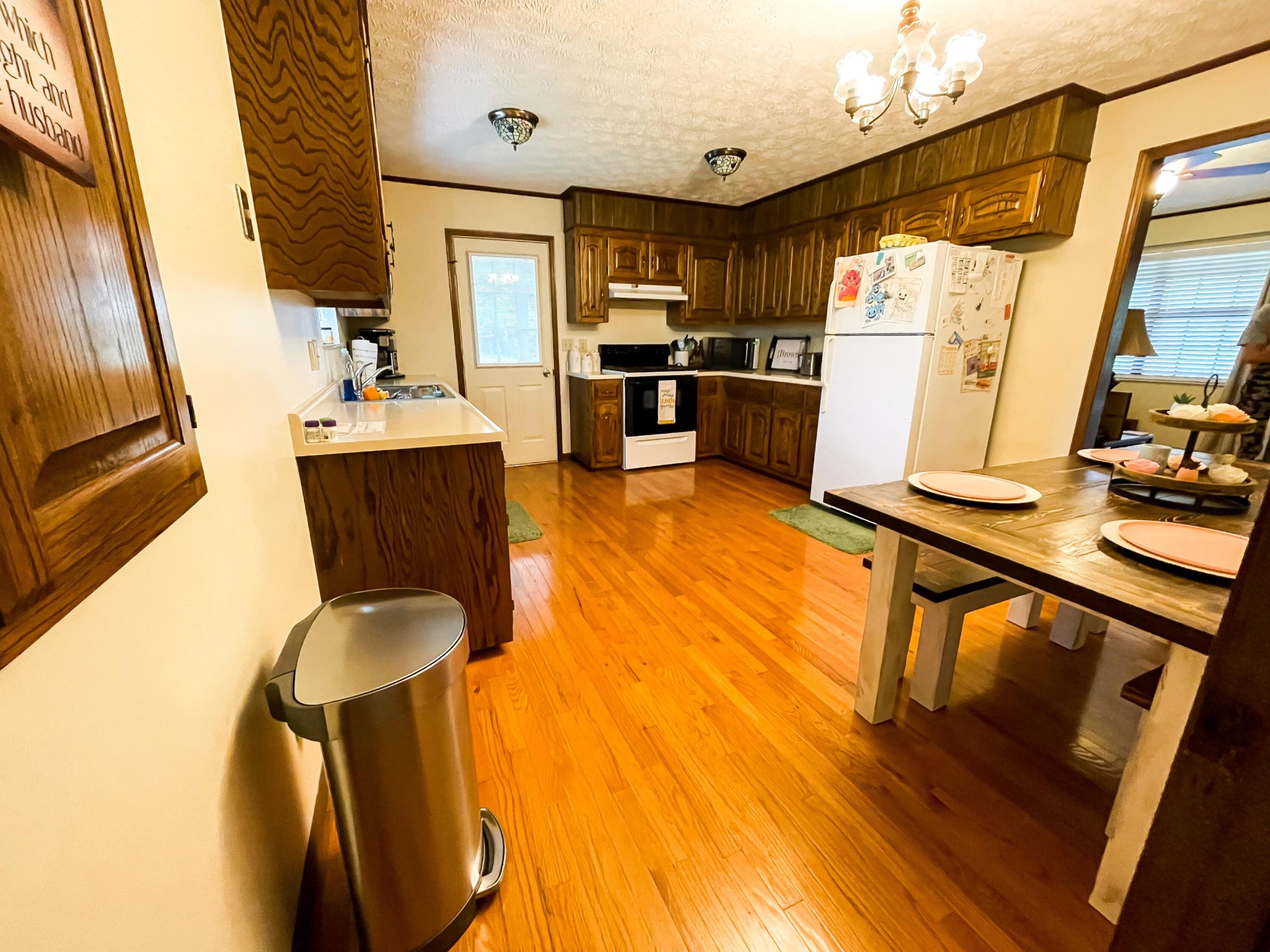 4935 Maple Hill Road Loudon, TN 37774 - Photo 8 of 16 a kitchen with stainless steel appliances a refrigerator a sink dishwasher a stove top oven a dining table and chairs with wooden floor