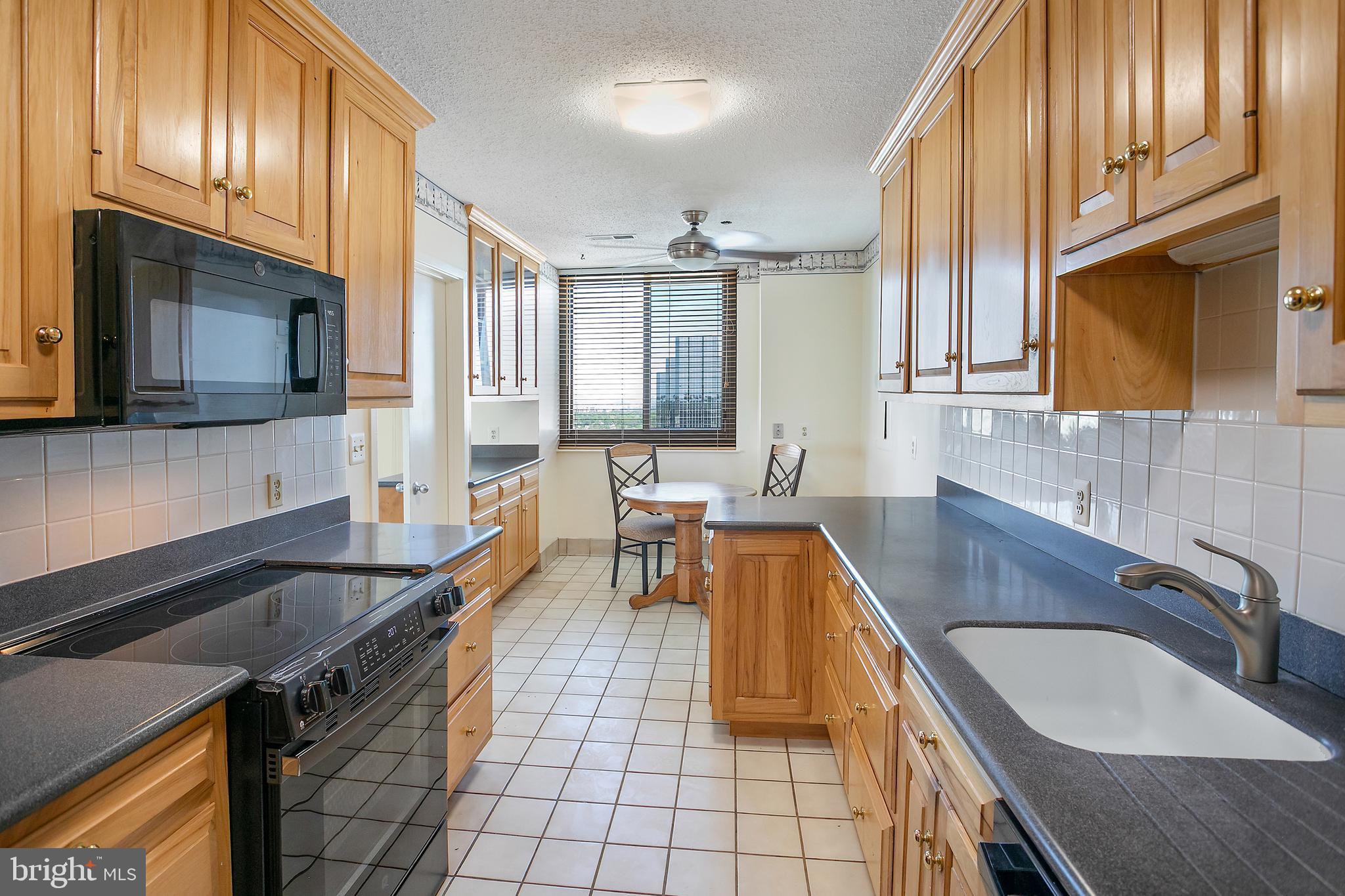 5505 Seminary Road, Unit 2605N Falls Church, VA 22041 - Photo 5 of 53 a kitchen with granite countertop a sink a stove top oven a dining table and chairs