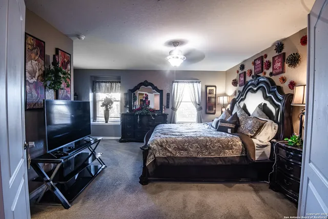 a bedroom with bed and a flat tv screen on dresser