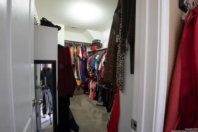a view of walk in closet with clothes