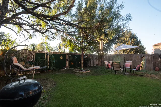 a view of a backyard with table and chairs and a fire pit