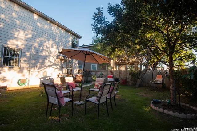a view of patio with table and chairs under an umbrella