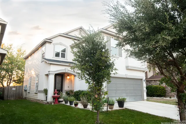 a front view of a house with a garden and plants